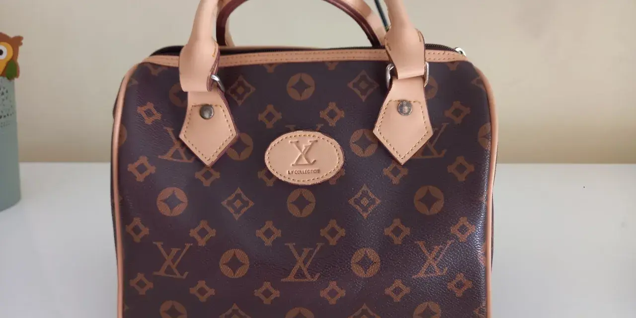 Brązowa louis vuitton torebka kuferek z monogramem. Elegancka, z jasnymi rączkami i detalami.