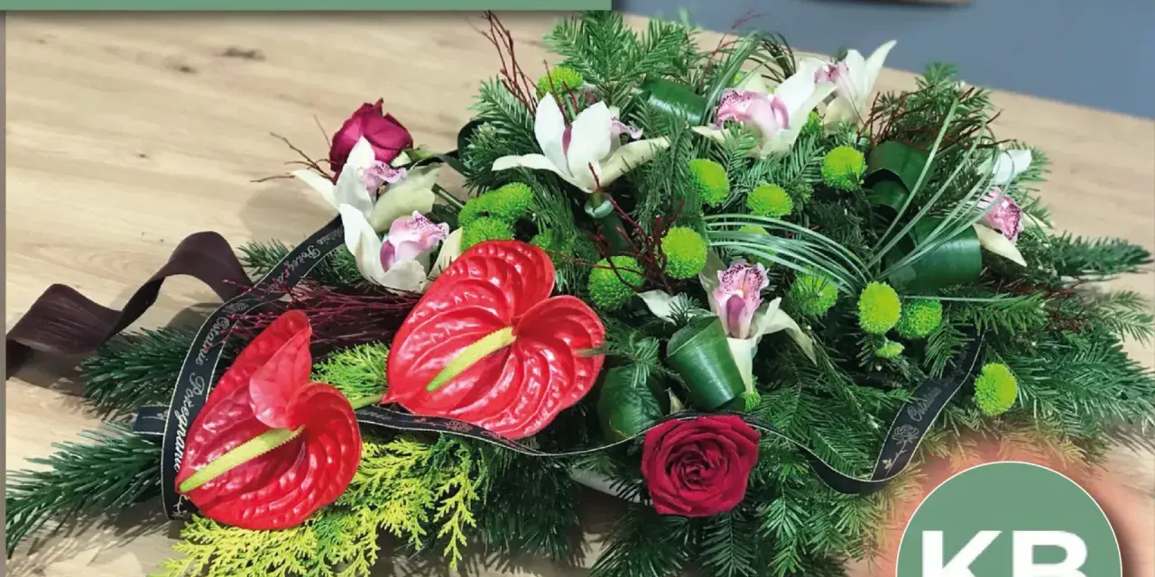 Eleganckie kwiaty na pogrzeb: anturium, róża, storczyki i zielone chryzantemy w stroiku z gałązek iglastych.