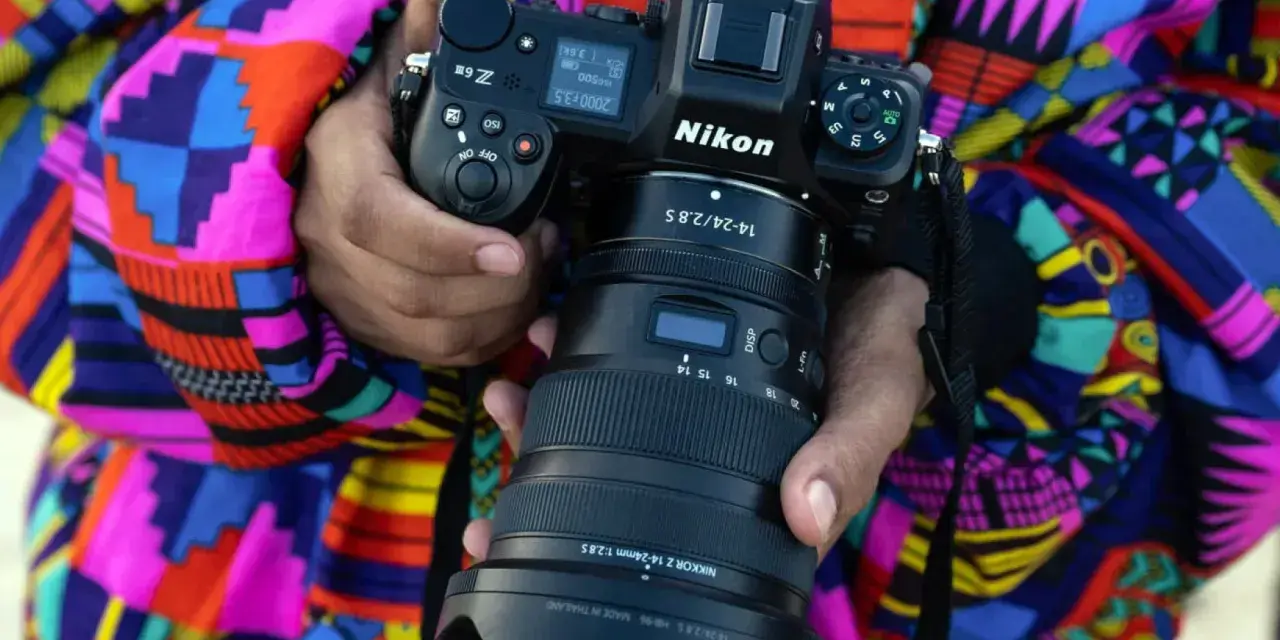 Osoba trzyma aparat Nikon Z6 z obiektywem NIKKOR Z 14-24mm f/2.8 S. Wśród wielu marek aparatów fotograficznych, Nikon wyróżnia się jakością.