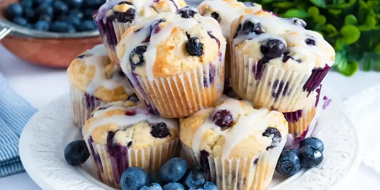 Wilgotne i puszyste muffinki z jagodami, polane lukrem. Idealne na śniadanie lub deser.