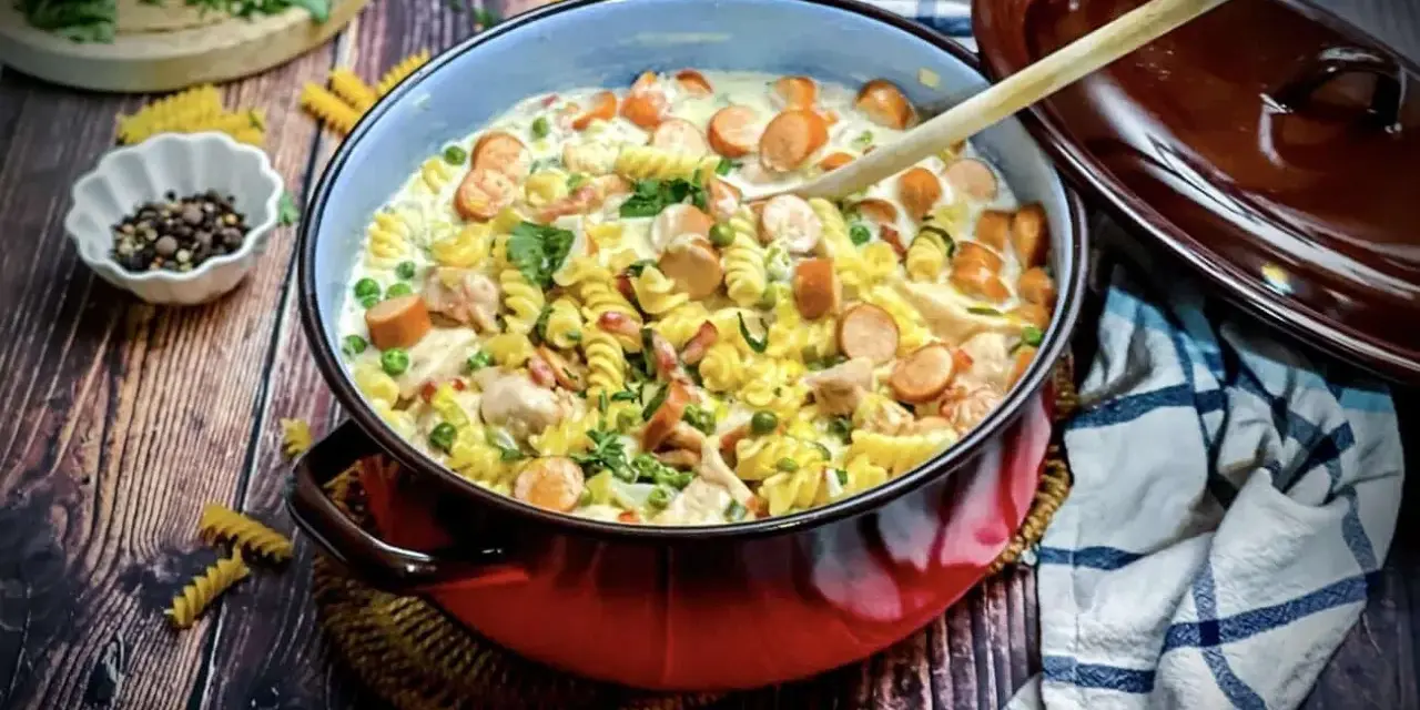 Herzhafte Nudelpfanne mit Würstchen, Erbsen und Hähnchen – ein Gericht, das perfekt für "das perfekte Dinner Rezepte" ist.