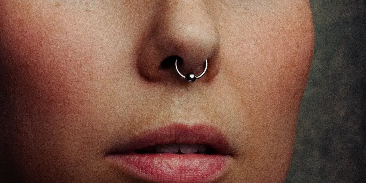 Zbliżenie na twarz z kolczykiem w nosie (septum). Czy septum boli? To pytanie zadaje sobie wiele osób przed piercingiem.