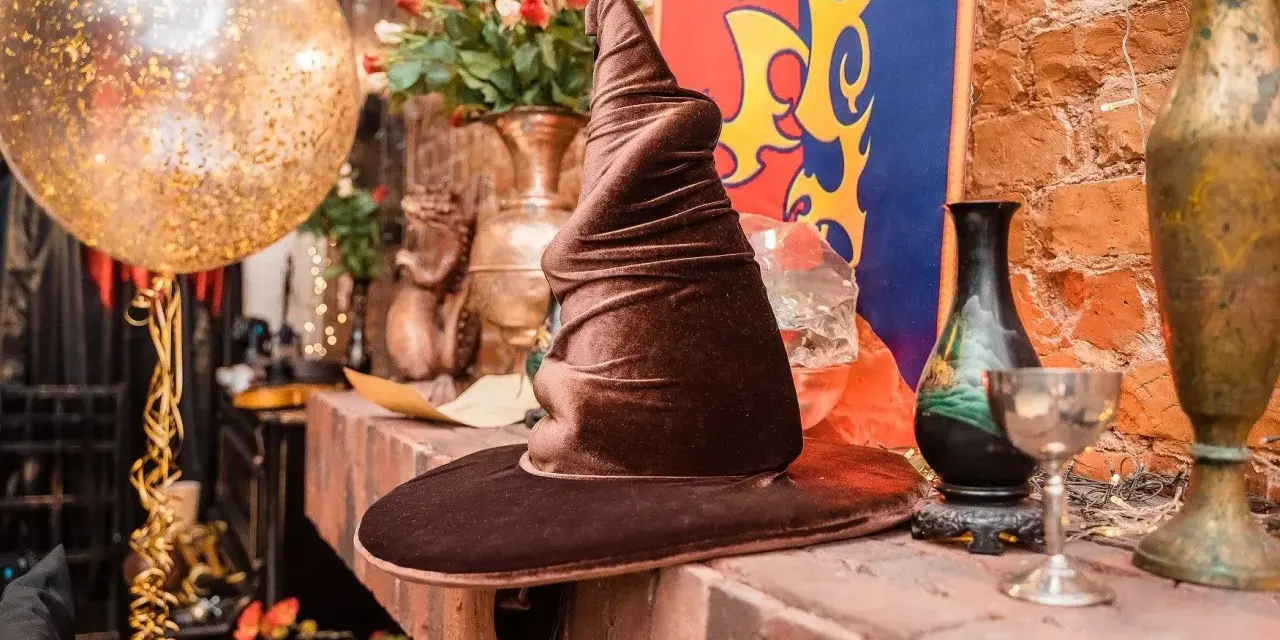 Czapka Mówiąca, złoty balon i bukiet róż tworzą magiczną atmosferę na weselu w stylu Harry'ego Pottera.