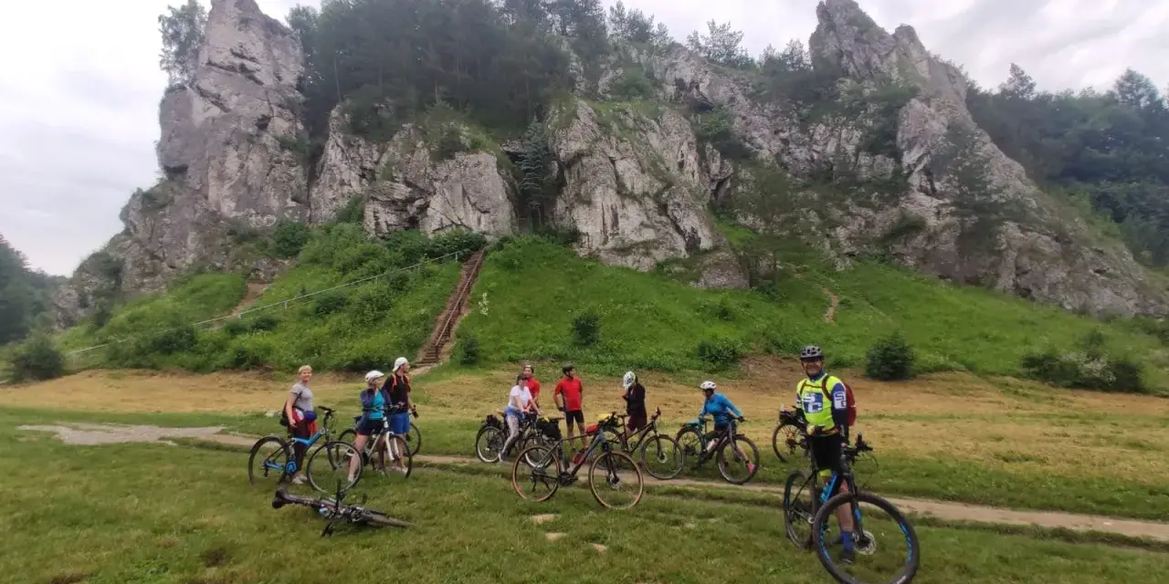 Grupa rowerzystów na tle skalnych ostańców. Jura Krakowsko-Częstochowska rowerem to wspaniała przygoda.