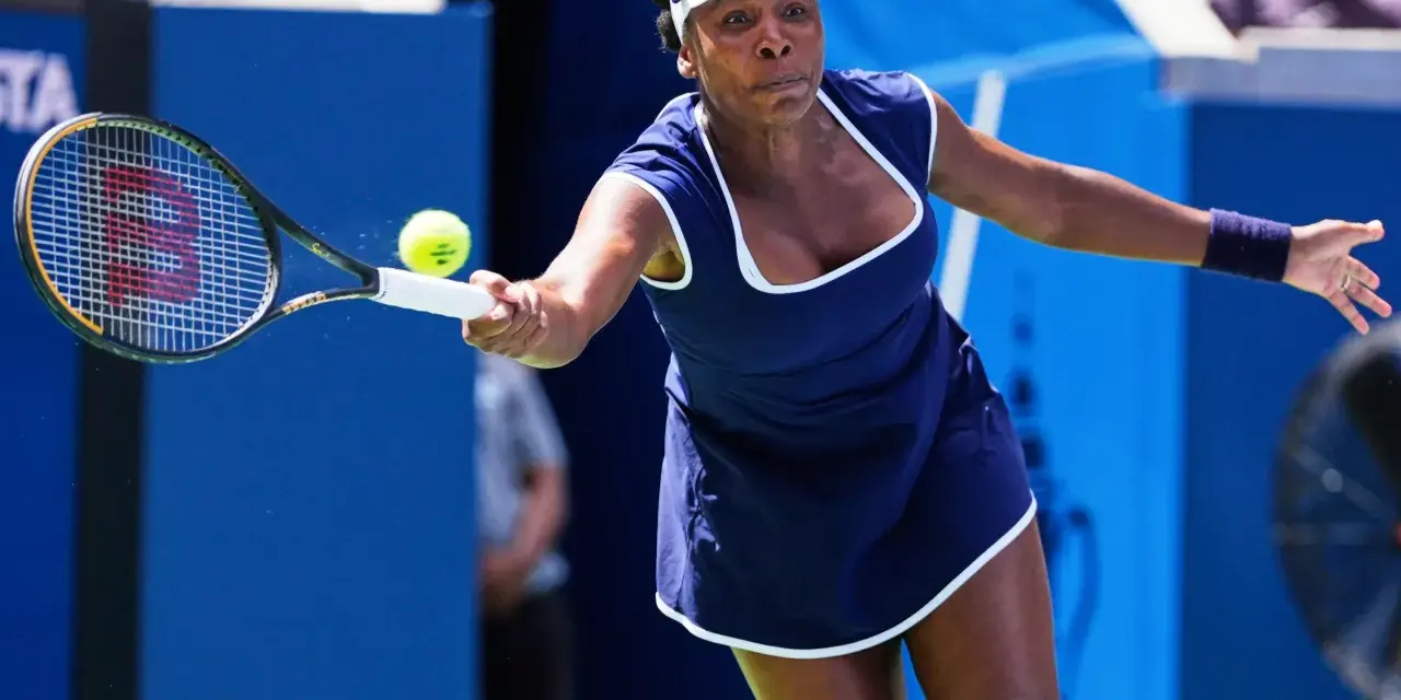 Venus Williams golpea la pelota en un partido, demostrando su destreza en los Grand Slams.