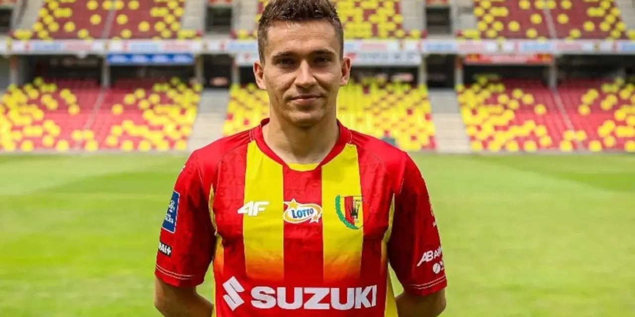 Piłkarz Korony Kielce w czerwono-żółtej koszulce na tle stadionu. Czekamy na kolejne transfery Korona Kielce!