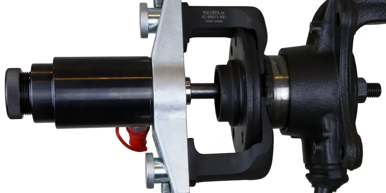 Automotive hub bearing removal and installation tool with a black hydraulic cylinder and silver clamp.