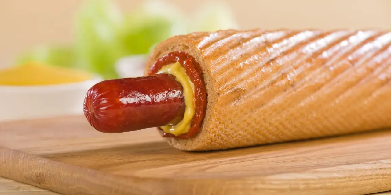 Pyszny hot dog francuski z musztardą i ketchupem, gotowy do zjedzenia.
