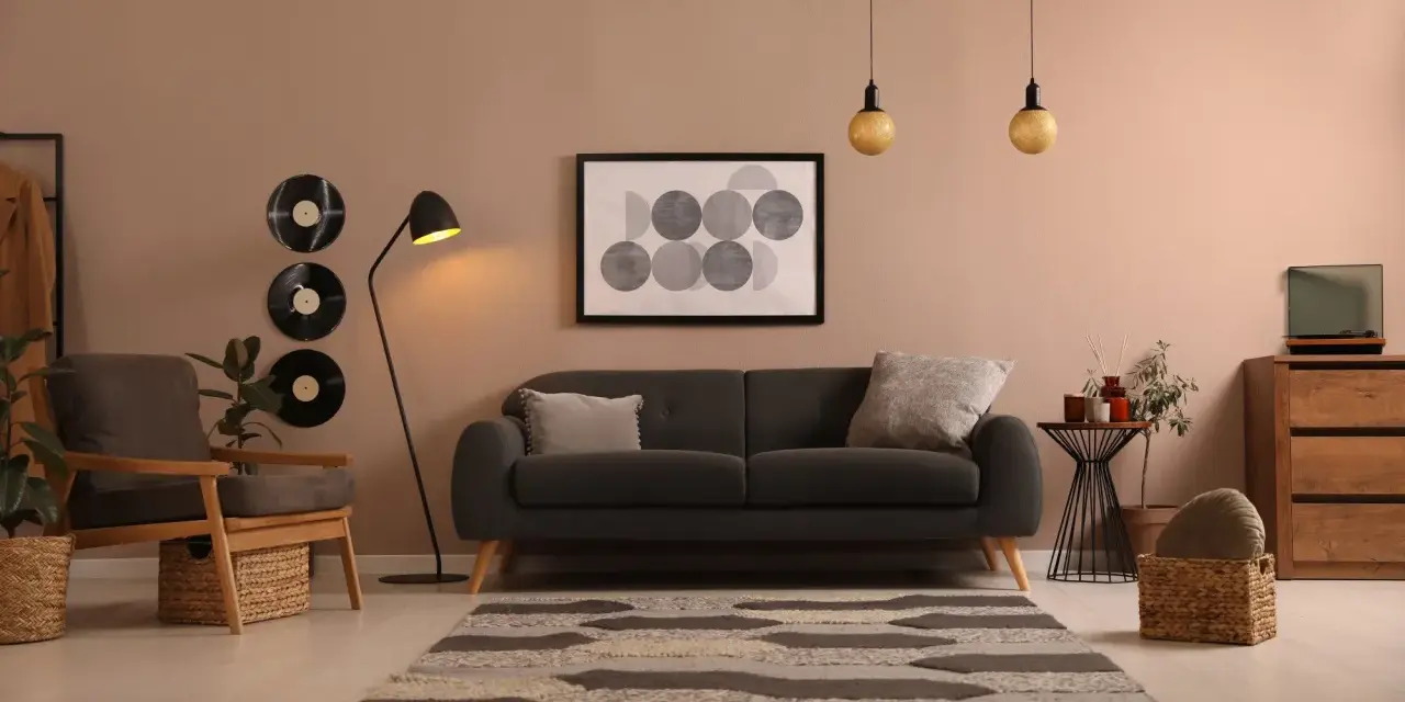 Idée déco salon avec canapé noir : ambiance cosy avec vinyles vintage, tapis graphique et fauteuil en bois.