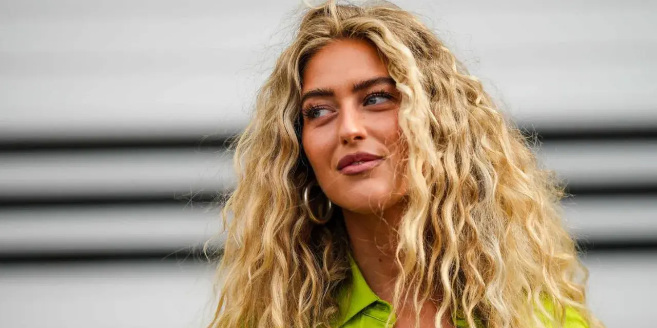 Frau mit voluminösen, blonden Locken, die zeigen, wie man Locken selber machen kann.