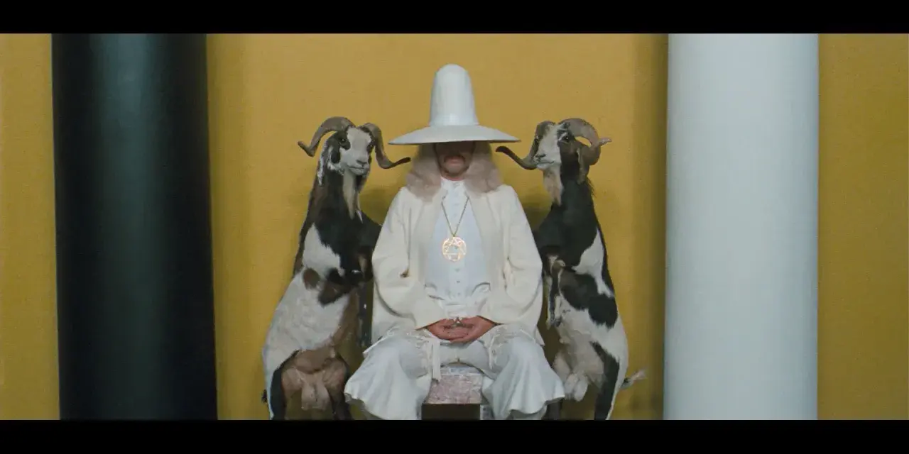Uomo con cappello conico bianco e due capre imbalsamate, simbolo de la montagna sacra Jodorowsky.