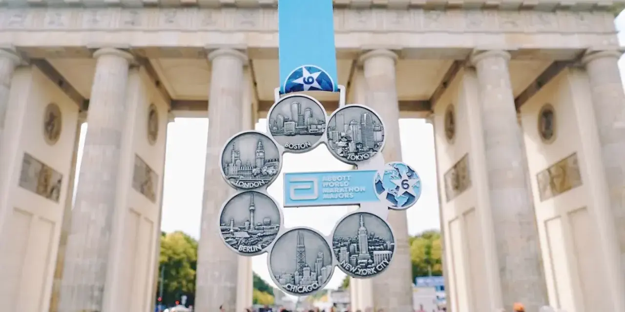 Medal za ukończenie korony maratonów świata z widokiem na Bramę Brandenburską.