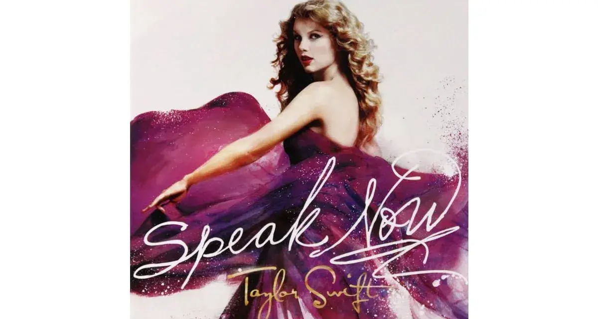 Taylor Swift w fioletowej sukni, z napisem "Speak Now".