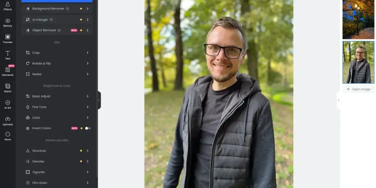 Mężczyzna w okularach uśmiecha się na tle parku. Interfejs programu Fotor oferuje darmowy program do obróbki zdjęć po polsku.