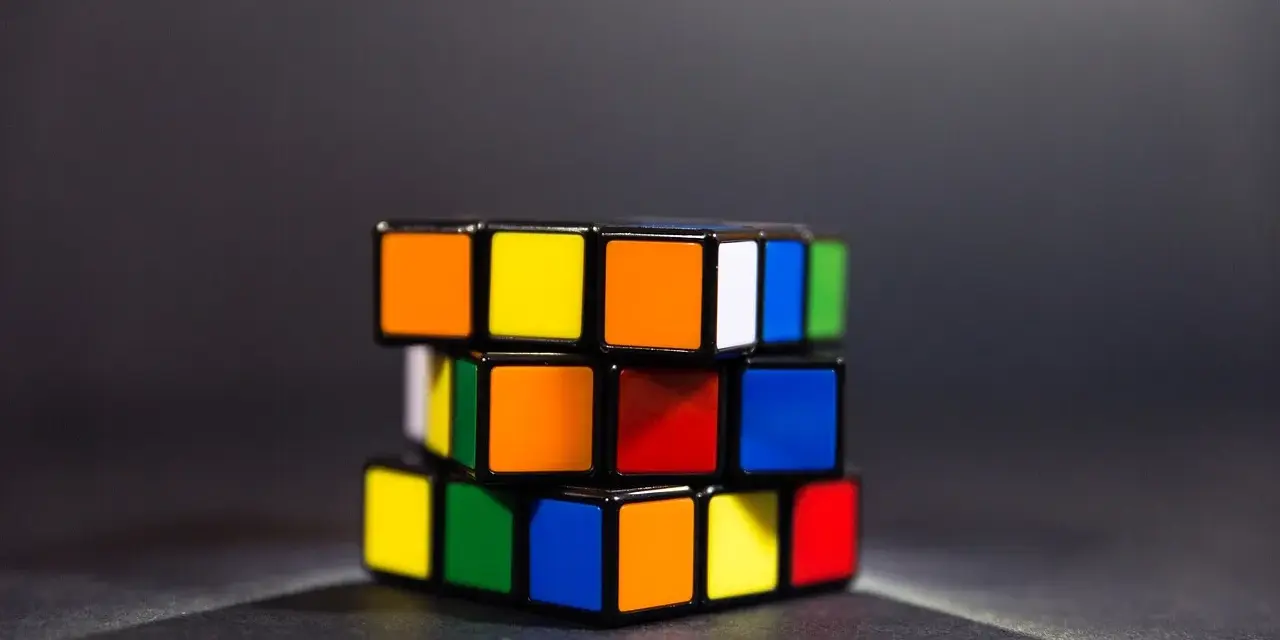 En färgglad speed cube ligger på ett mörkt underlag.