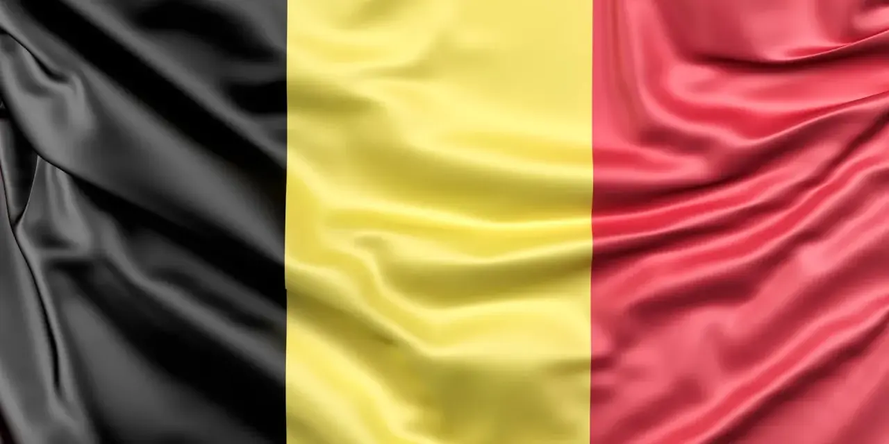 Falująca belgijska flaga z pionowymi pasami: czarnym, żółtym i czerwonym.