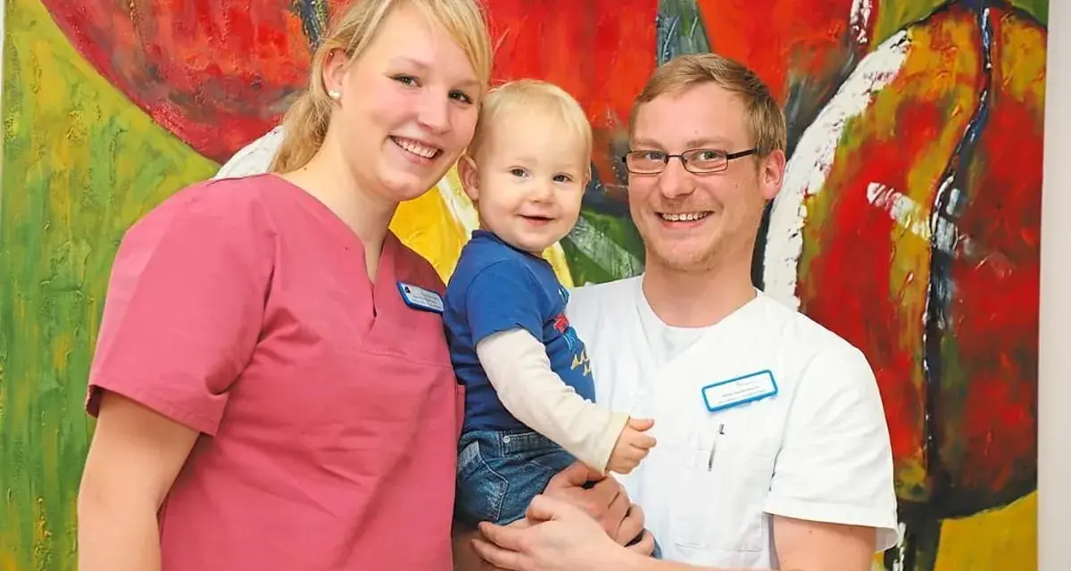 Glückliche Familie vor bunter Kunst. Das Bild thematisiert das Arbeitsrecht bei Schichtarbeit mit Kind.