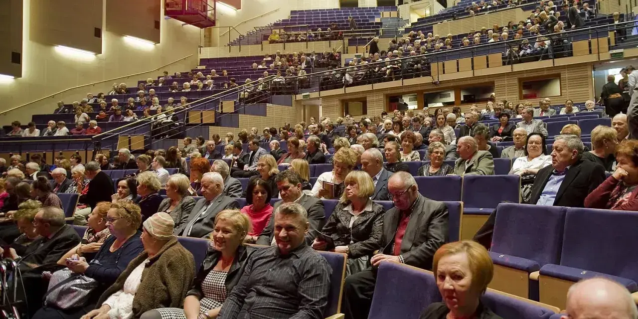 Widownia sali koncertowej, ludzie w eleganckich strojach, inspiracja: jak ubrać się na koncert muzyki filmowej.