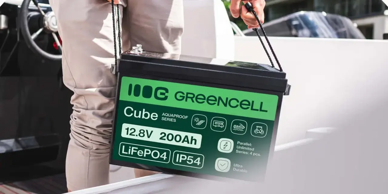 Mężczyzna niesie akumulator LiFePO4 12.8V 200Ah marki Greencell Cube. To jeden z rodzajów akumulatorów, idealny do łodzi, kamperów i wózków golfowych.