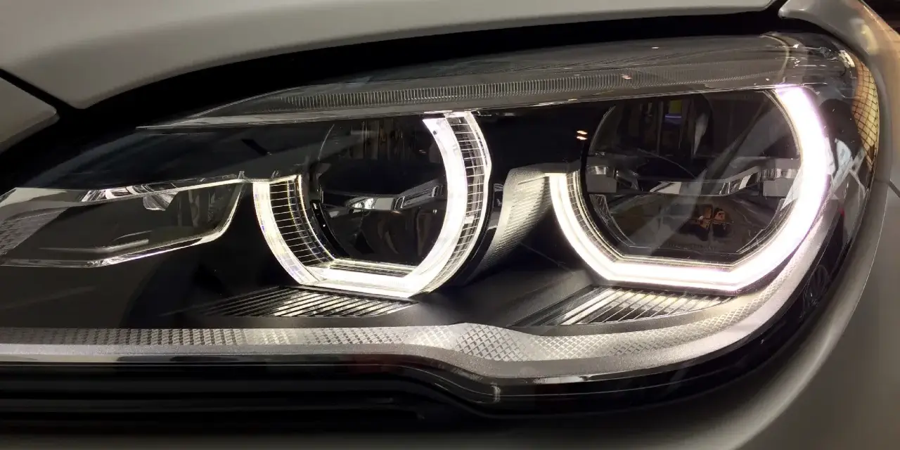 Nahaufnahme eines modernen Autoscheinwerfers mit leuchtendem Standlicht.