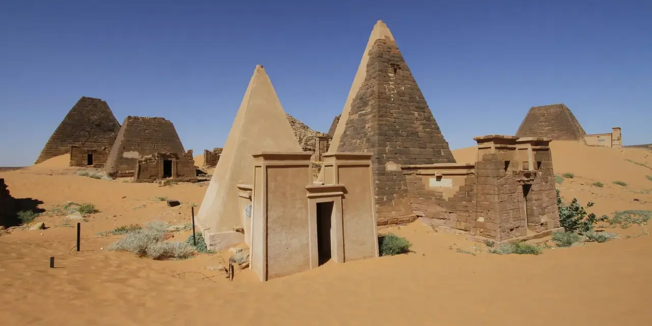 Niezwykłe piramidy w Meroe, fascynujące miejsca na sudan wycieczki. Piasek pustyni otacza starożytne budowle.