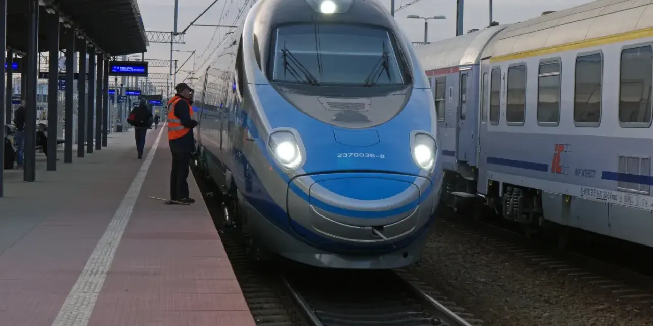 Pendolino Warszawa-Kraków na peronie. Maszynista w kamizelce odblaskowej czeka na pasażerów.