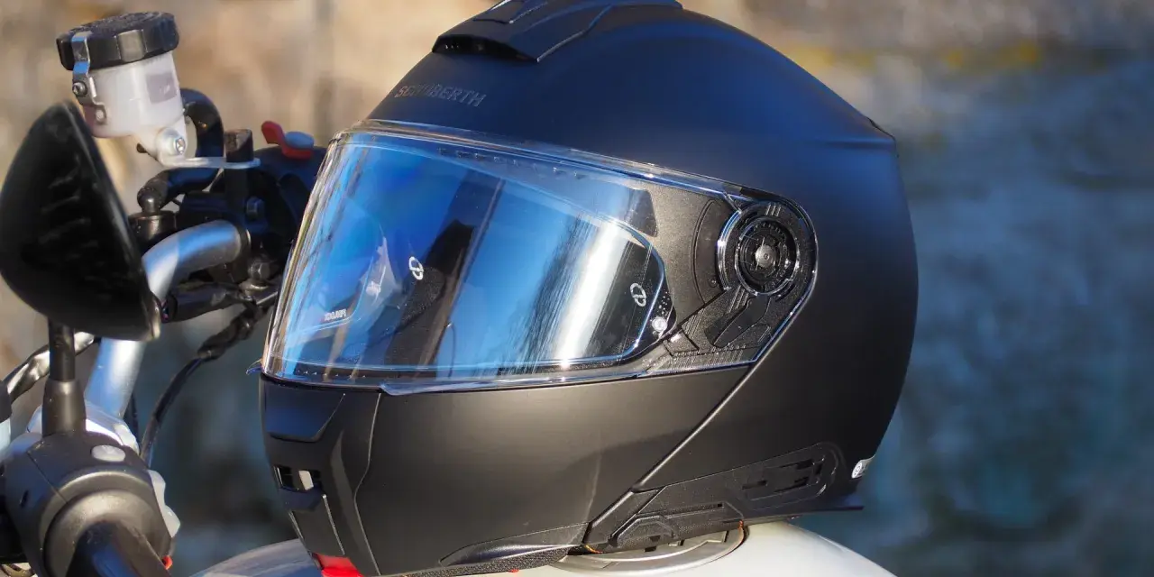 Casco Schuberth C5 negro con visera azul sobre una moto.