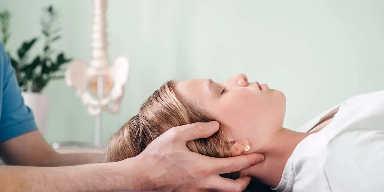 Delikatna terapia krzyżowo czaszkowa dla ulgi w napięciu. Terapeuta delikatnie uciska głowę pacjentki.