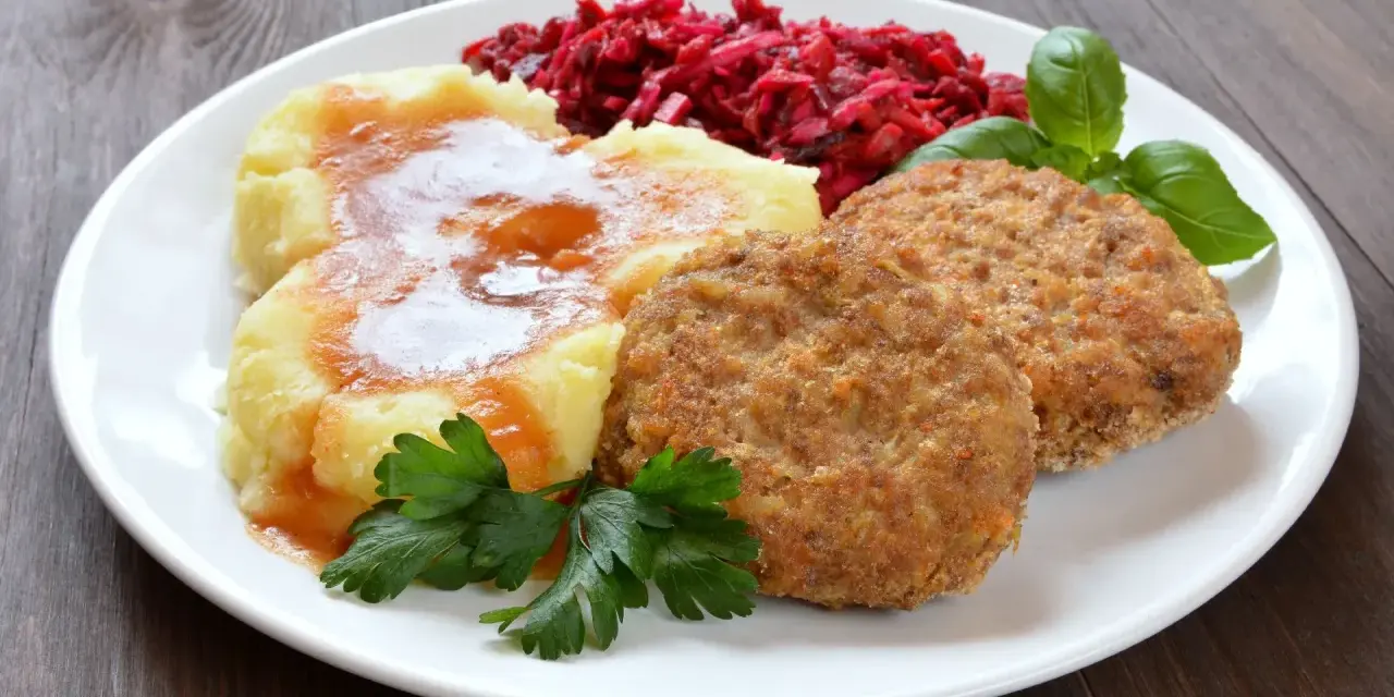 Dwa soczyste mielone z piekarnika, podane z purée ziemniaczanym polanym sosem, surówką z buraków i listkami bazylii.
