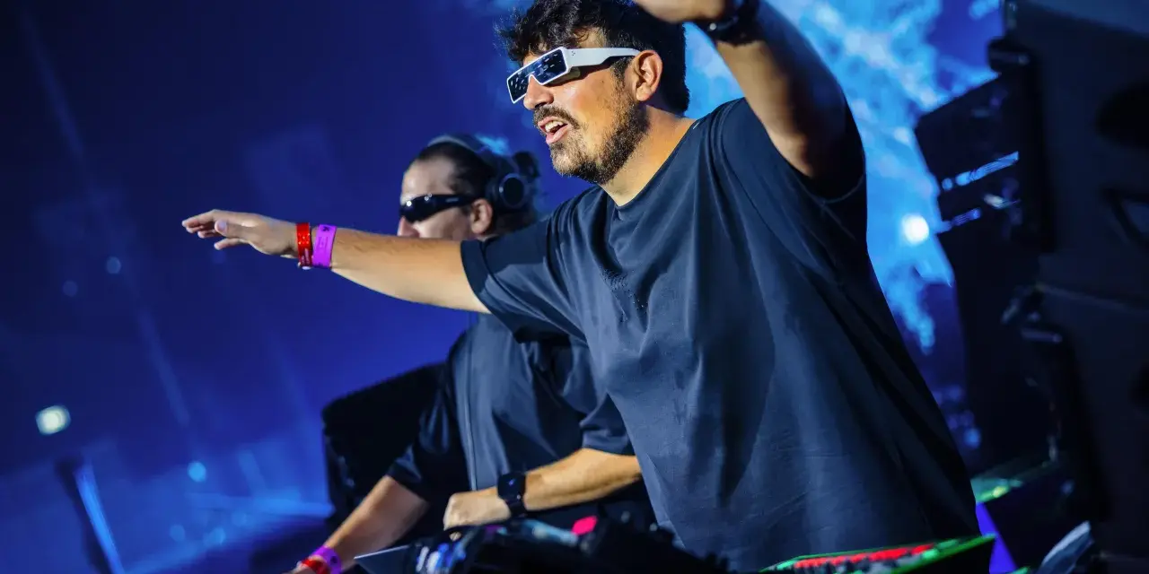 Dwaj DJ-e, niczym agenci czasu, manipulują dźwiękiem na scenie. Jeden w futurystycznych okularach, drugi w słuchawkach, obaj w transie.