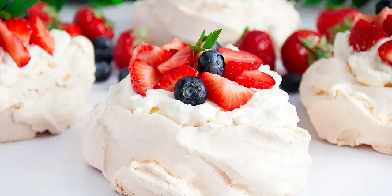 Klasyczna Pavlova z owocami i kremem lub małe beziki z kremem. Pyszne, lekkie desery.
