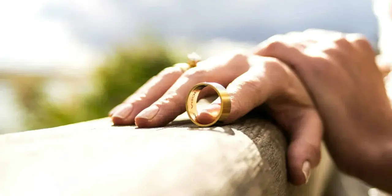 Une main tient une alliance, symbole d'un mariage qui se termine. La question se pose : peut-on avoir le même avocat pour divorcer ?