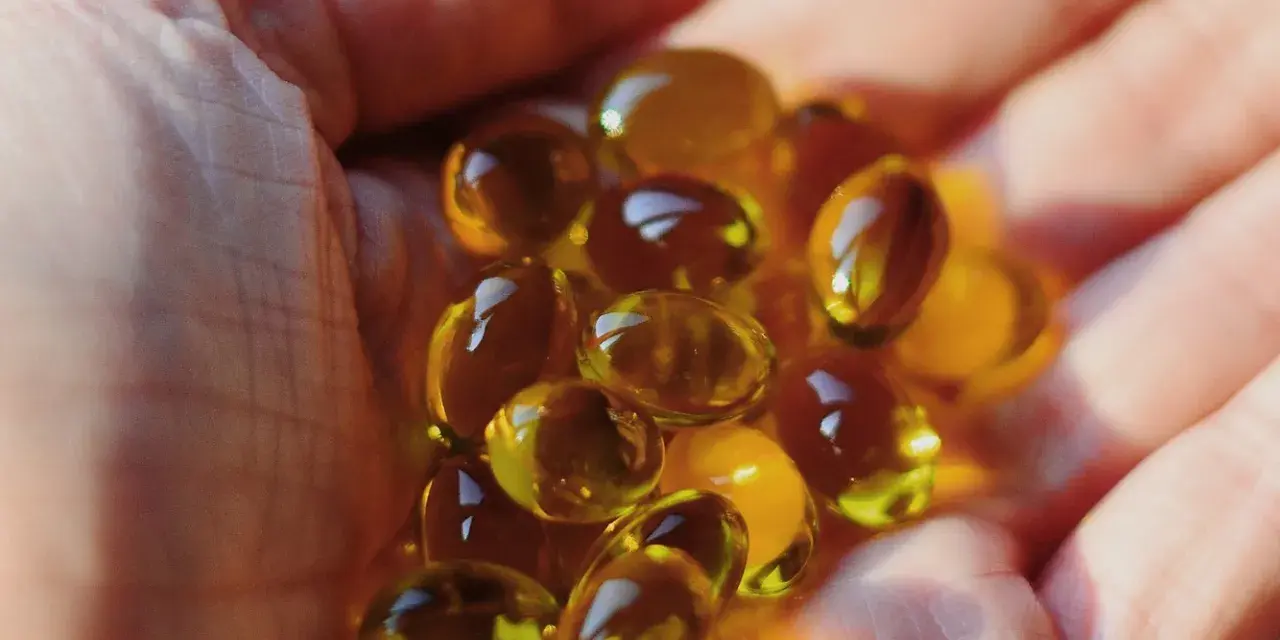 Une main tient des capsules d'huile de bourrache et onagre, un soutien naturel pour la ménopause.