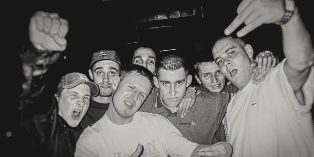 HZOP feat. Dudek RPK & RPS - każdy z nas. Grupa młodych mężczyzn pozuje do zdjęcia, jeden z nich pokazuje znak rock'n'rolla.