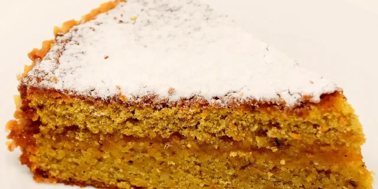 Wilgotne ciasto marchewkowe posypane cukrem pudrem. Idealne na deser, choć warto sprawdzić ciasto marchewkowe kcal przed zjedzeniem.