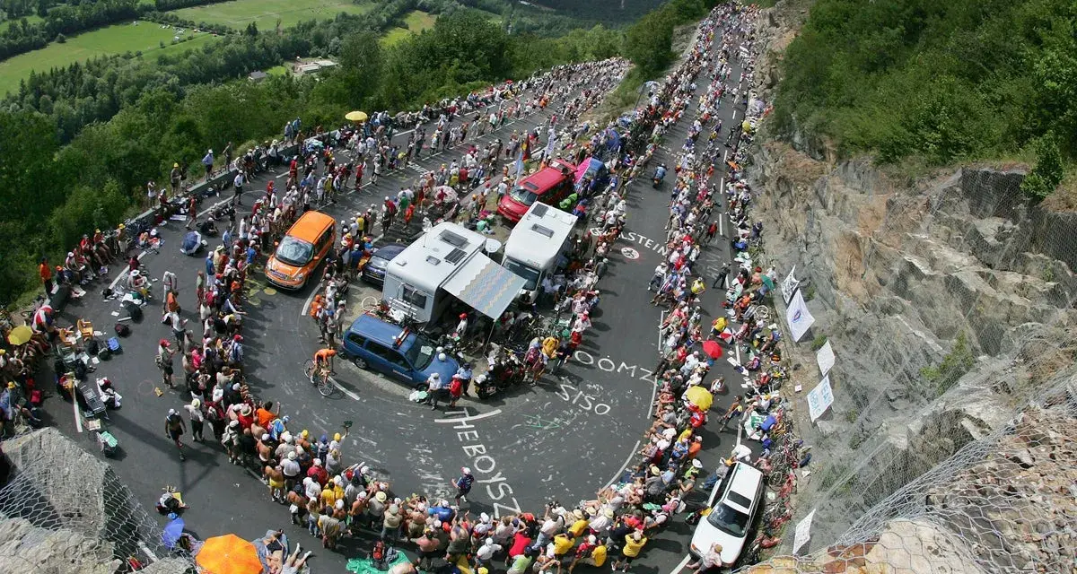 Spectators line the winding road of Alpe d'Huez for the Tour de France, a sea of color and anticipation.