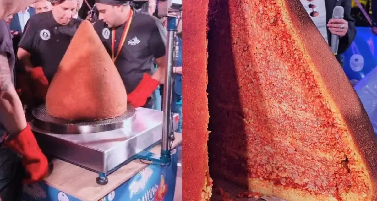 A giant arancino is presented, with a slice cut to reveal its rice and meat filling.