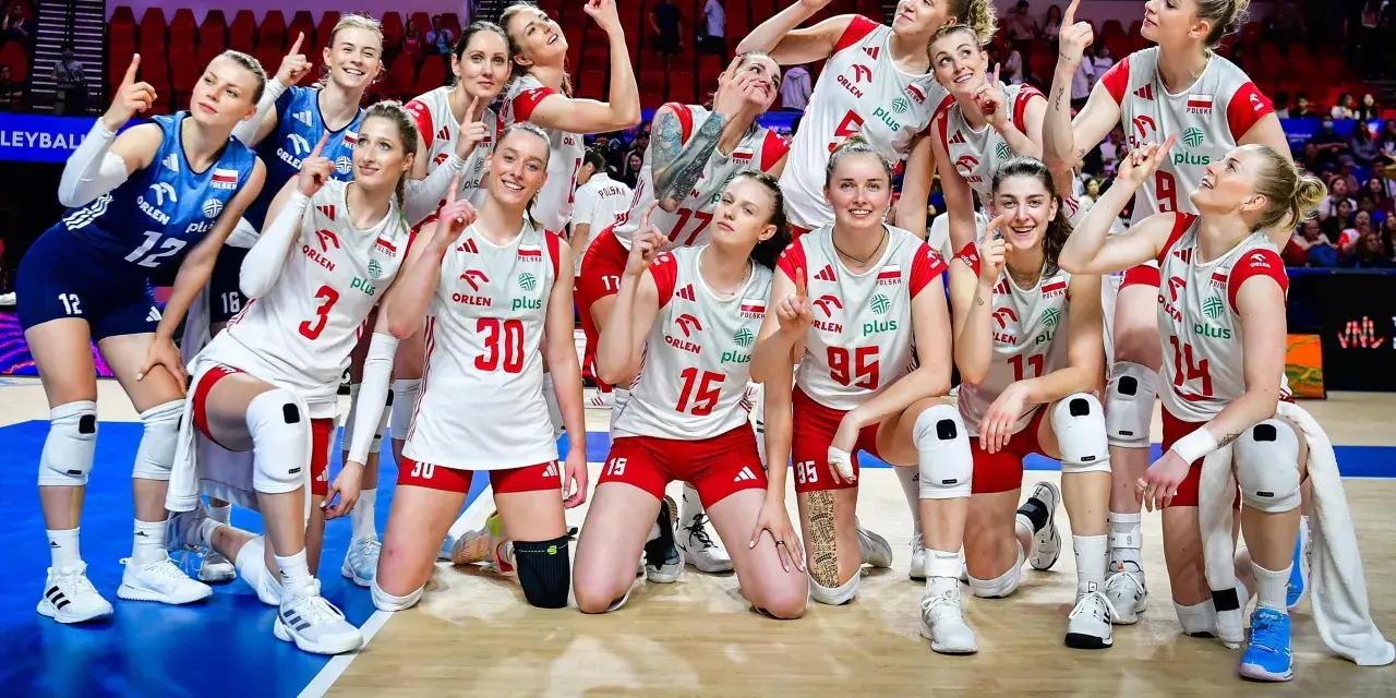 Siatkarki reprezentacji Polski w siatkówce, uśmiechnięte, pozują do zdjęcia, wskazując palcami w górę.