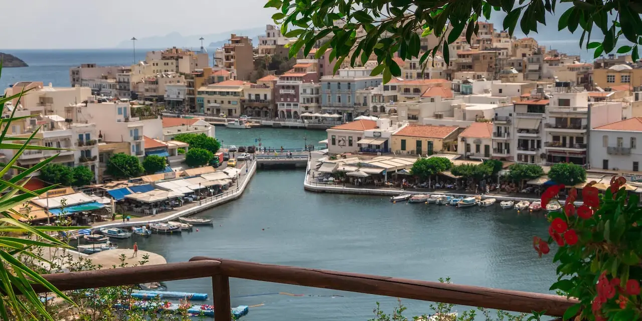Malowniczy widok na port w Agios Nikolaos na Krecie. Woda lśni, a nadbrzeże tętni życiem.