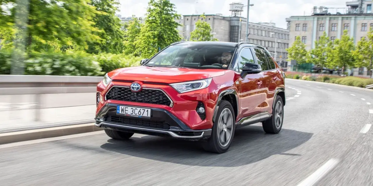 Czerwona Toyota RAV4 Hybrid na drodze miejskiej.