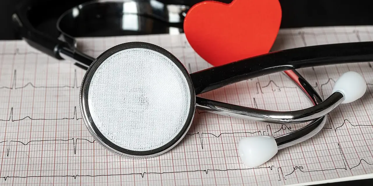 Stetoskop i czerwone serce na tle EKG.