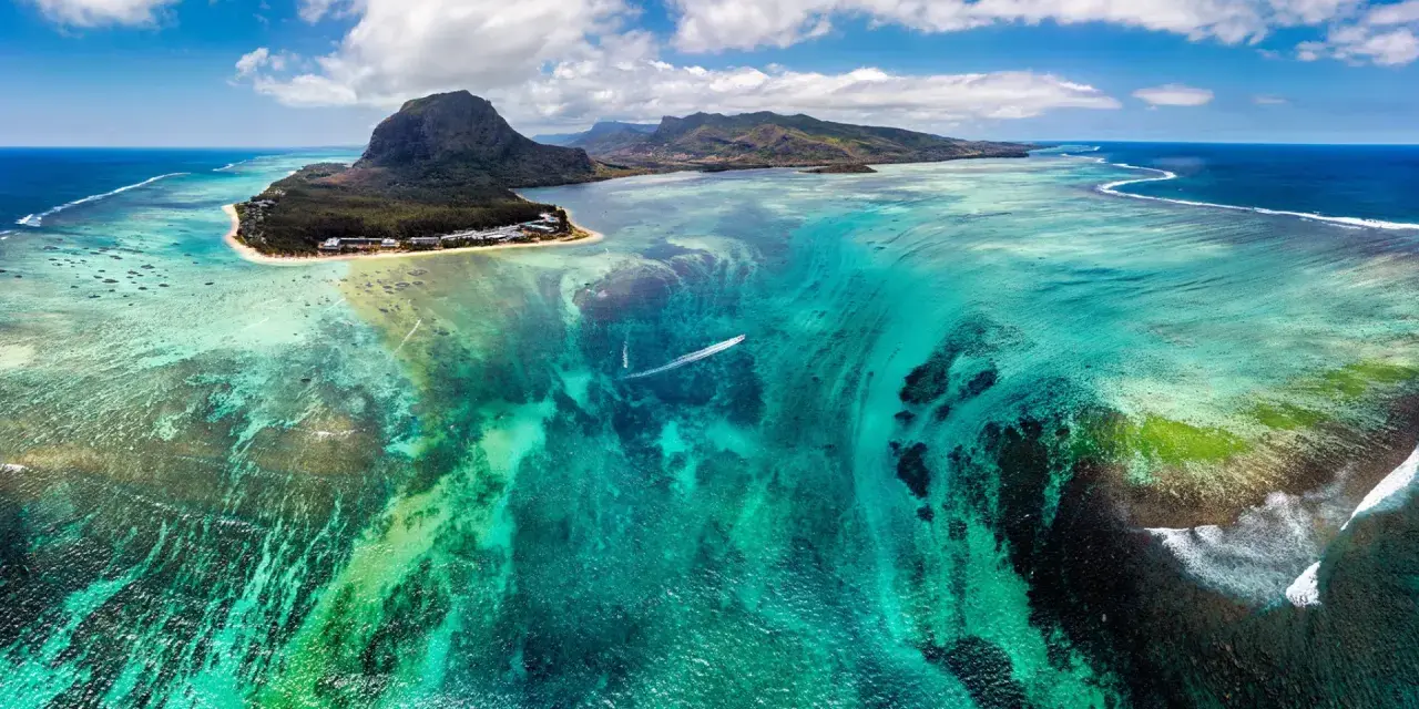 Widok z lotu ptaka na turkusowe wody i góry Mauritiusa. Marzysz o podróży? Mauritius wiza to pierwszy krok do raju.