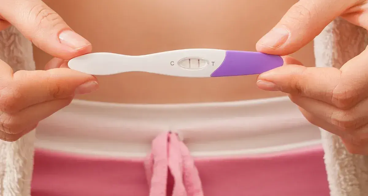 Dwie kreski na teście ciążowym pokazują, jak działa test ciążowy. Wynik pozytywny.