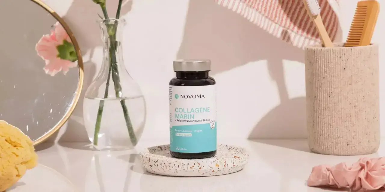 Flacon de cure de collagène marin Novoma, posé sur un plateau décoratif, près d'un miroir, d'une fleur et d'une brosse à dents.