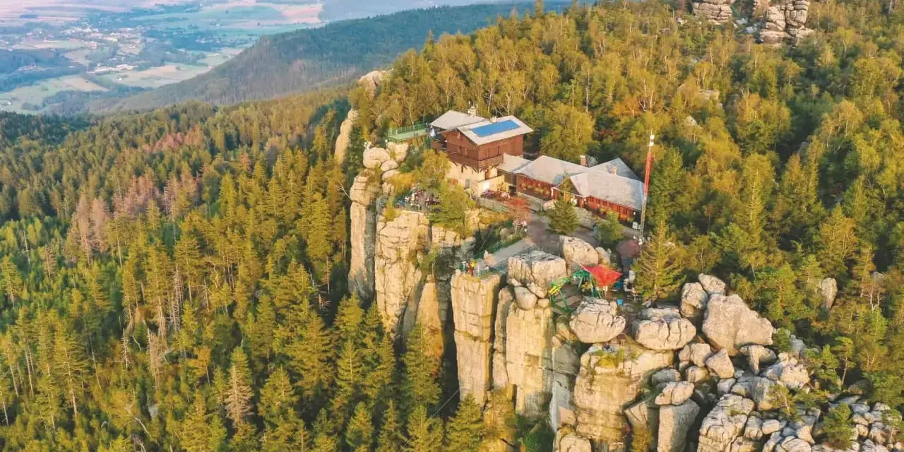 Widok na Szczeliniec Wielki. Idealny czas zwiedzania to lato, gdy można podziwiać piękne widoki i odpocząć w schronisku.