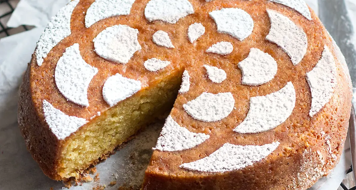 Deliziosa caprese al limone, soffice e profumata, con decorazione a fiore di zucchero a velo.