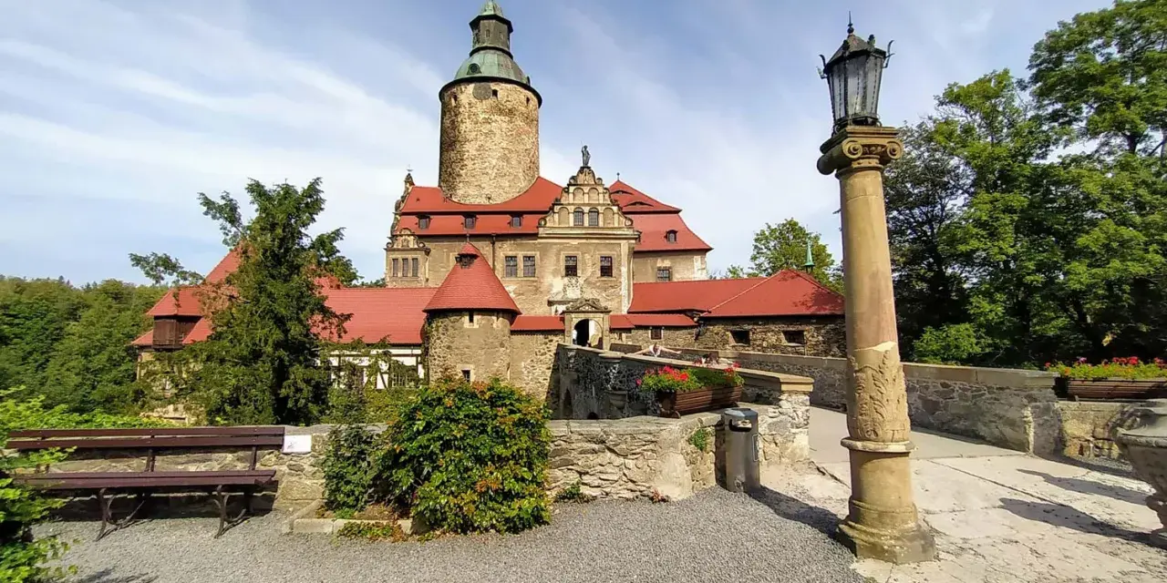 Zamek Czocha, gdzie jest? Ten malowniczy zamek z czerwonymi dachami i wieżą góruje nad okolicą, otoczony zielenią.