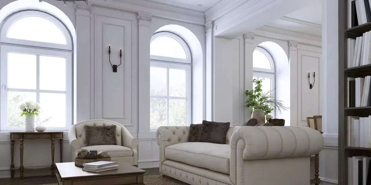 Elegancki salon z sofą, fotelem i książkami na półce.