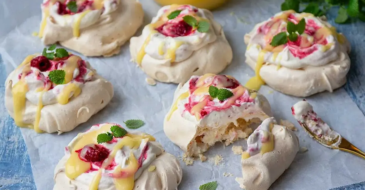 Små pavlovakakor med grädde, hallon och citronsås. En perfekt liten dessert!