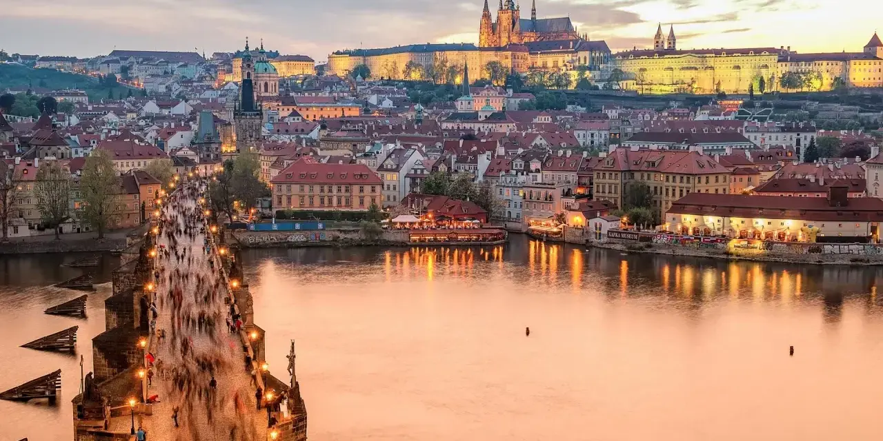 Zachód słońca nad Pragą, tłumy na Moście Karola. Czy do Czech potrzebny jest paszport? Nie, wystarczy dowód osobisty.